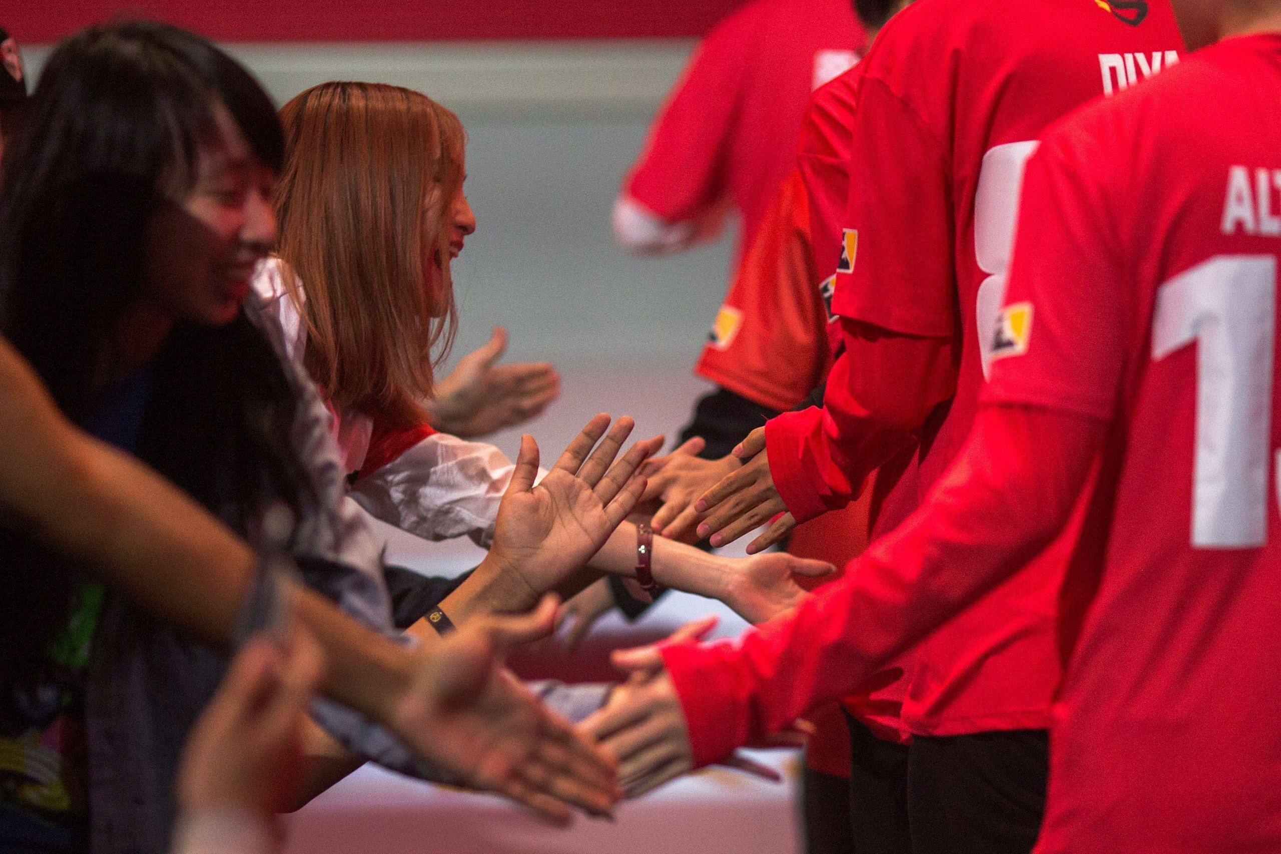 Fans reach out to Shanghai Dragons players as they prepare to play the New York Excelsior. (DAVID MCNEW/AFP/Getty Images)